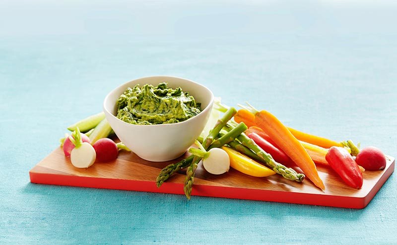 Plate of veggies with avocado spinach green yogurt dip