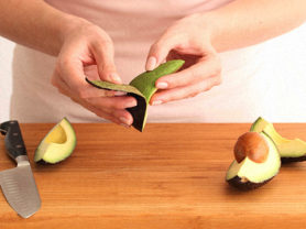 A quarter of an avocado being peeled