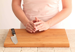 Hands resting on a clean cutting board