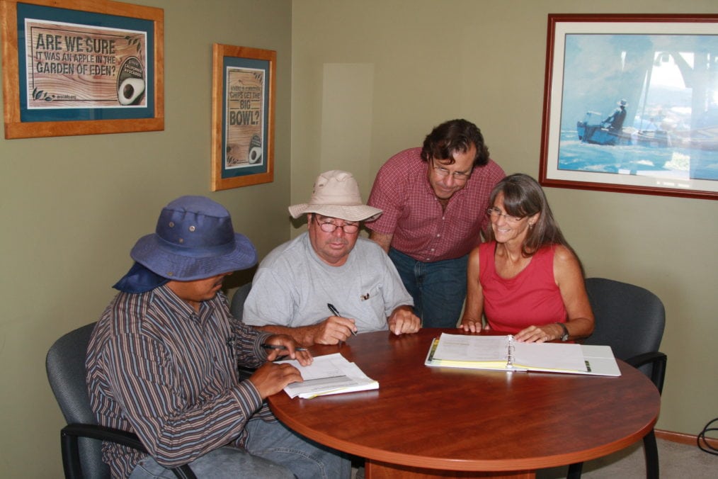 A California Avocado grower and three employees at a training session in an office.