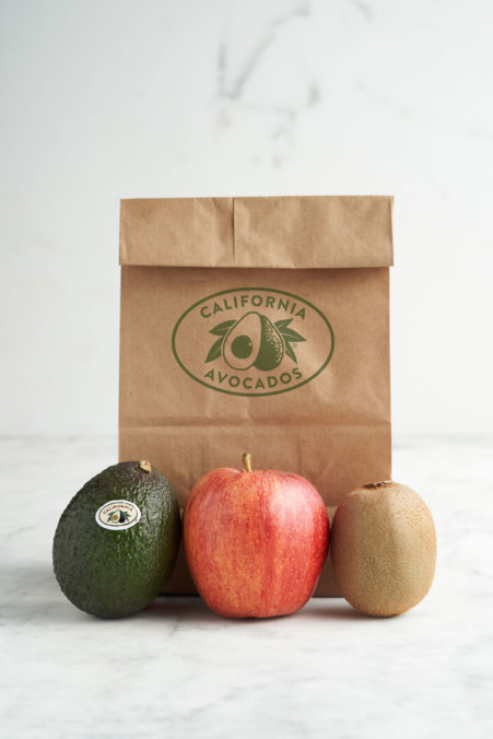 image of a paper back and an avocado, apple and kiwi