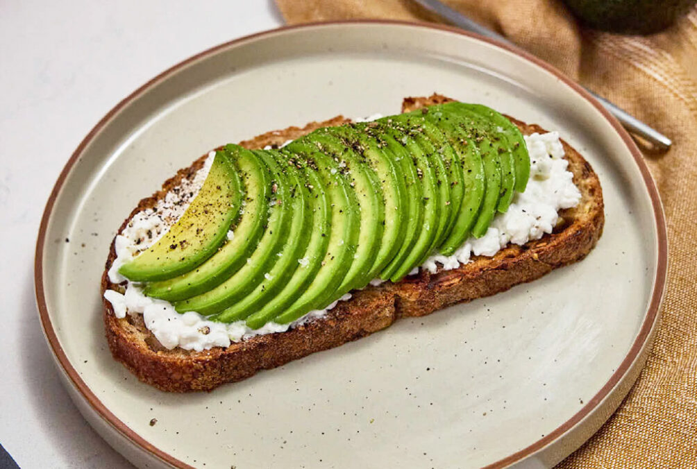 California avocado toast with cottage cheese, ground black pepper and flaky sea salt.